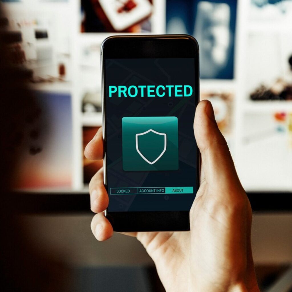 A person holds a smartphone displaying a PROTECTED screen with a shield icon, indicating security features in a digital space.