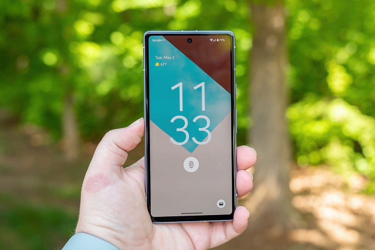 A hand holds a smartphone displaying the time as 11:33, date as May 2, and temperature as 62°F, with a green background.