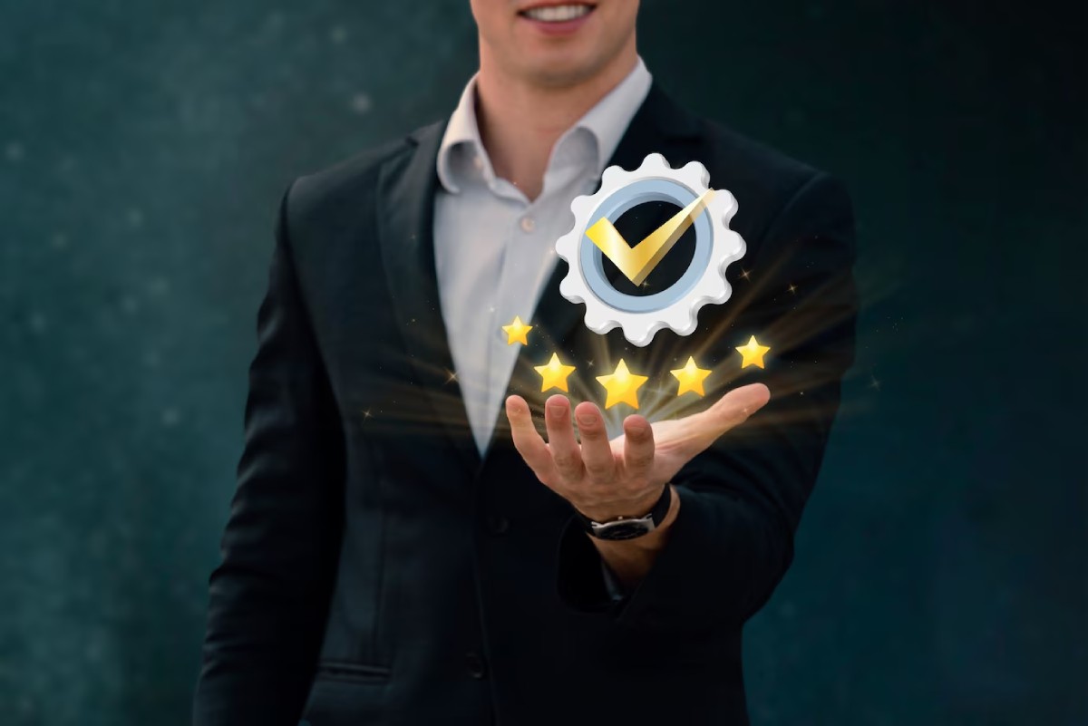 A businessman in a suit smiles while holding a glowing gear with a check mark and five stars hovering over his palm.