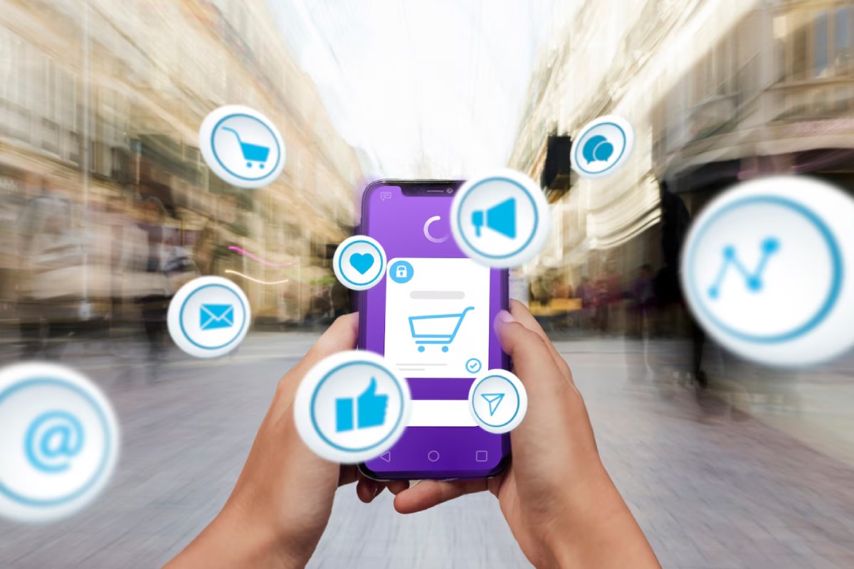 A person is holding a smartphone with a shopping interface, surrounded by social media icons, in a blurred urban background.