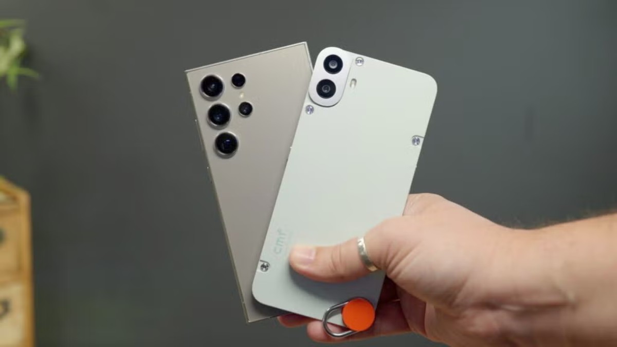 A hand holding two smartphones: a silver model with multiple camera lenses and a white model with fewer cameras, showcasing their design.