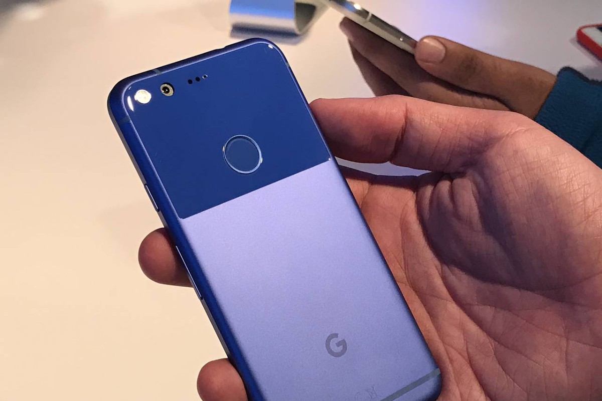 A person's hand holding a blue Google Pixel phone, showcasing its dual-tone design and circular fingerprint sensor on the back.